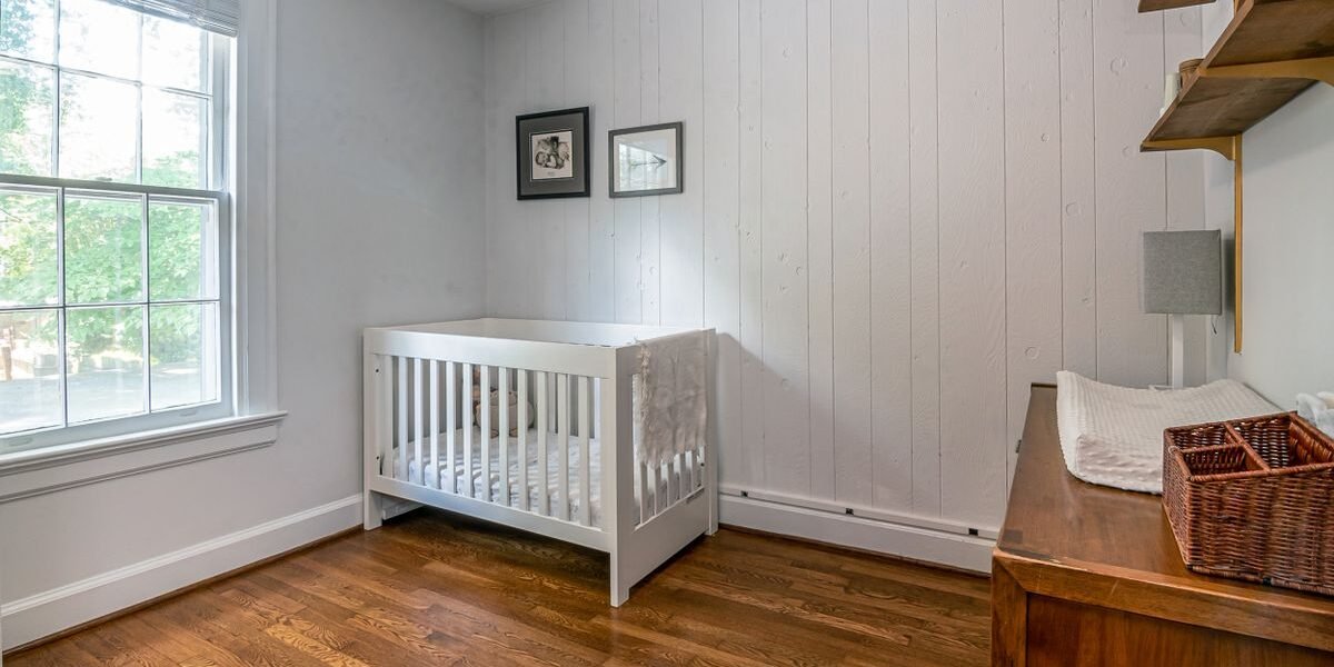 Wit ledikant met lade eronder in een lichte babykamer