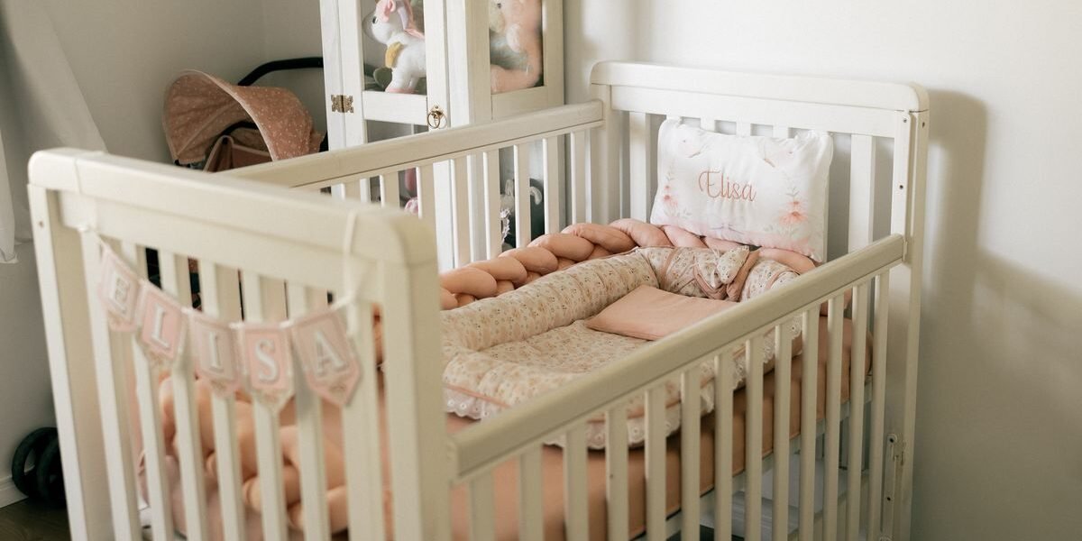 Ovaal ledikant op wieltjes naast een ouderbed