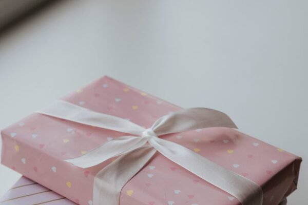 Origineel baby cadeau: ingepakt pakje met maandkaarten en houten speelboog