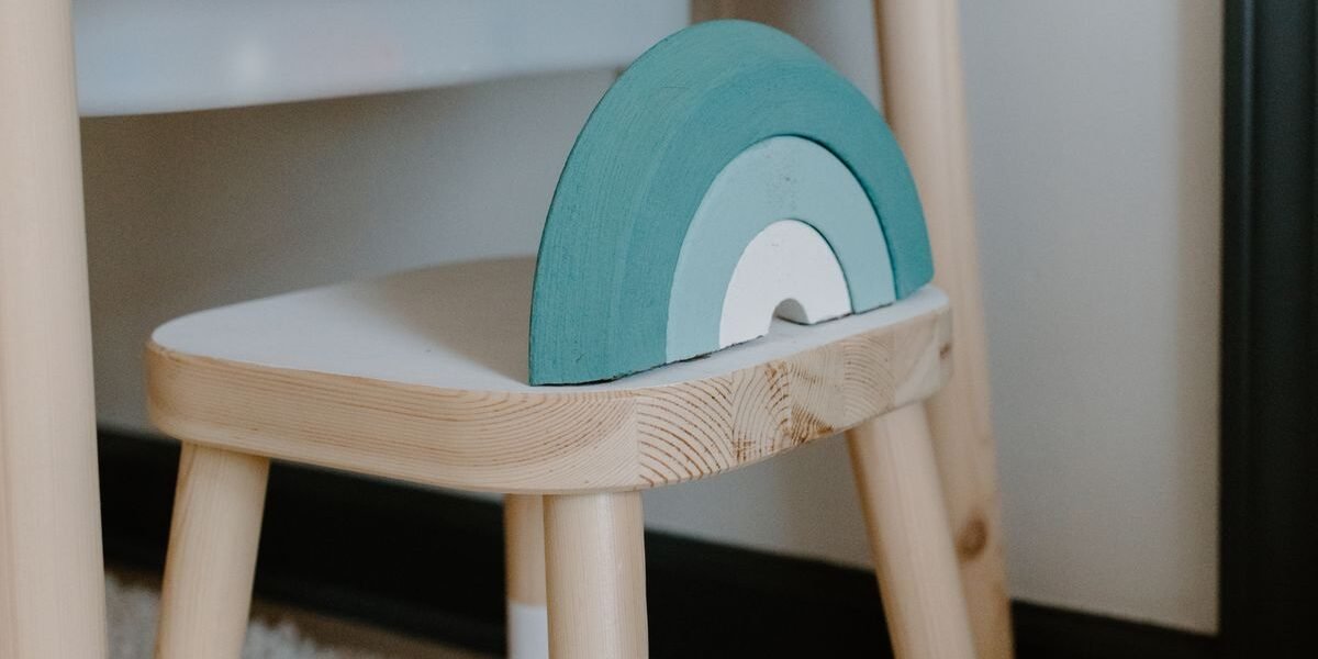 Houten kinderstoeltje met naam gegraveerd in een babykamer