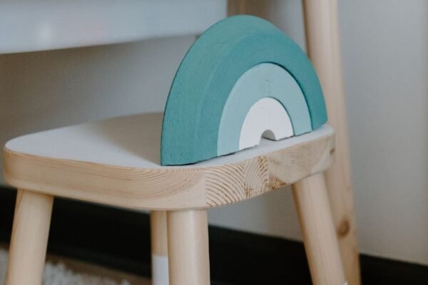 Houten kinderstoeltje met naam gegraveerd in een babykamer