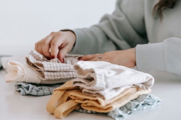 Tips baby uitzet: babykleding per maat gesorteerd op een commode