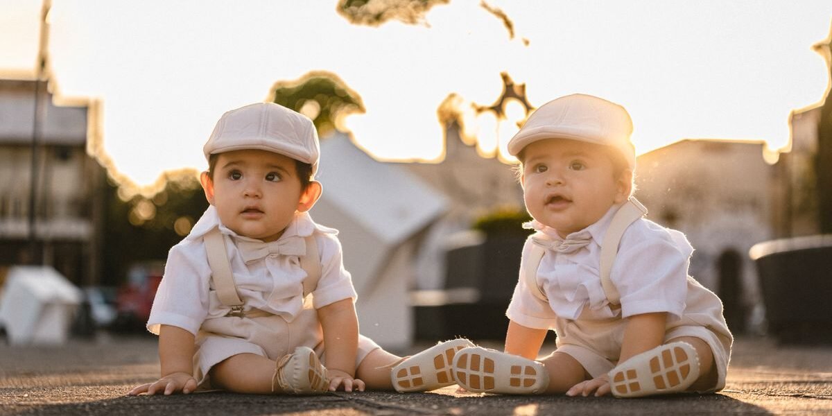 Ouders met een pasgeboren tweeling in twee wiegjes