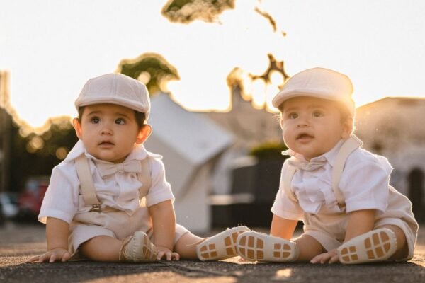 Ouders met een pasgeboren tweeling in twee wiegjes