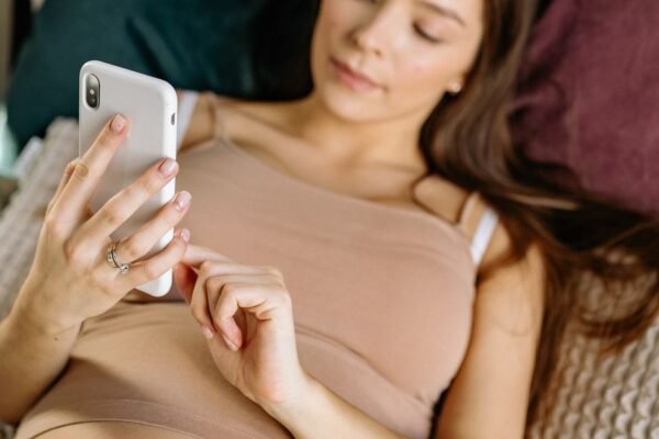 Moeder maakt verlanglijstje online op laptop naast kinderwagen