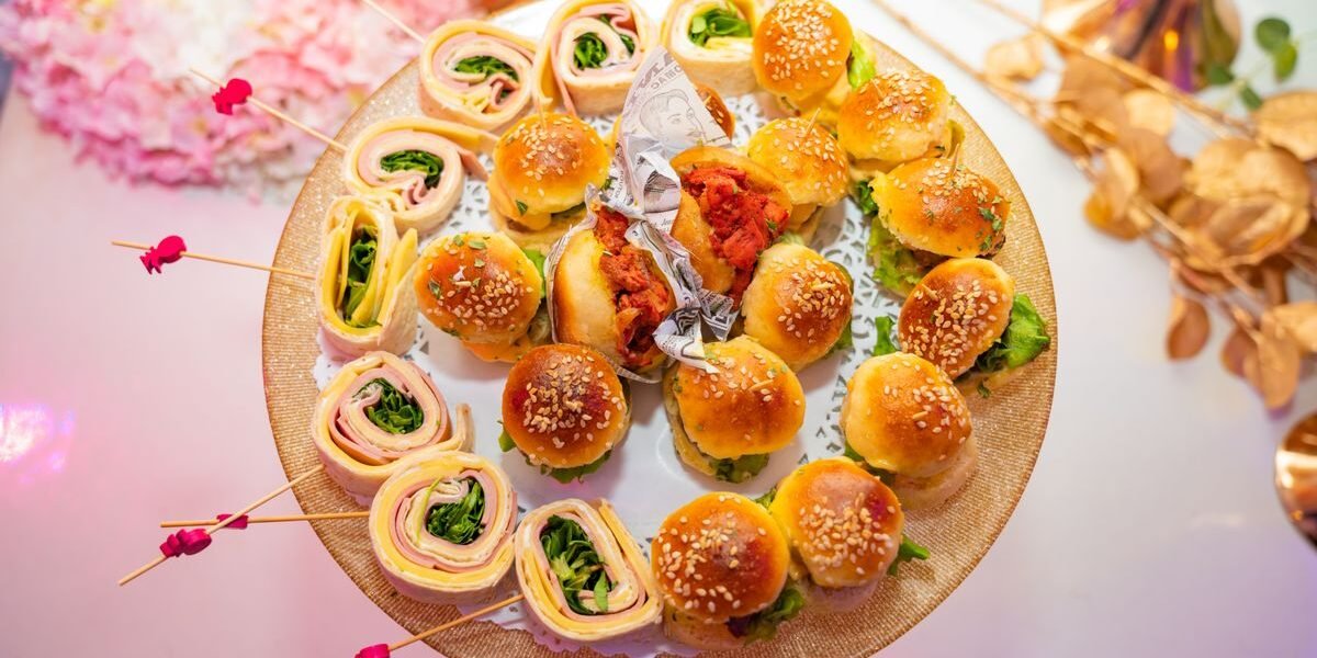 Schotel met mini-sandwiches en wraps, ideaal om te serveren op een babyborrel
