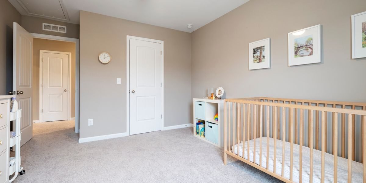 Lichte babykamer goedkoop ingericht met een eenvoudig houten ledikant