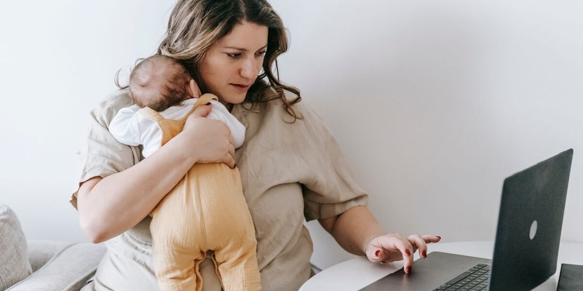 Werkende moeder met baby aan laptop, plant wanneer ze gaat kolven