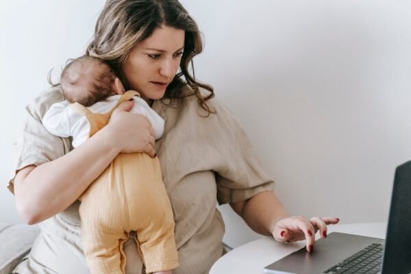 Werkende moeder met baby aan laptop, plant wanneer ze gaat kolven