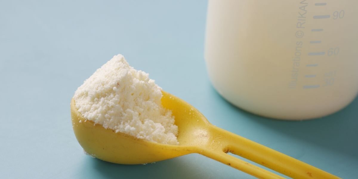 Maatschepje melkpoeder en maatbeker voor de juiste hoeveelheid flesvoeding