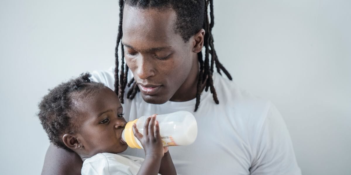Vader geeft zijn baby een opgewarmde fles flesvoeding
