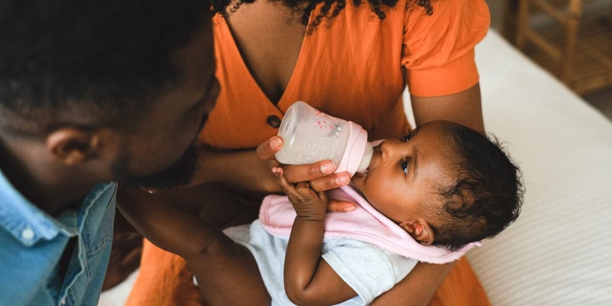 Baby drinkt flesvoeding uit een fles met speen, close-up