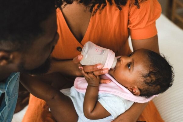 Baby drinkt flesvoeding uit een fles met speen, close-up