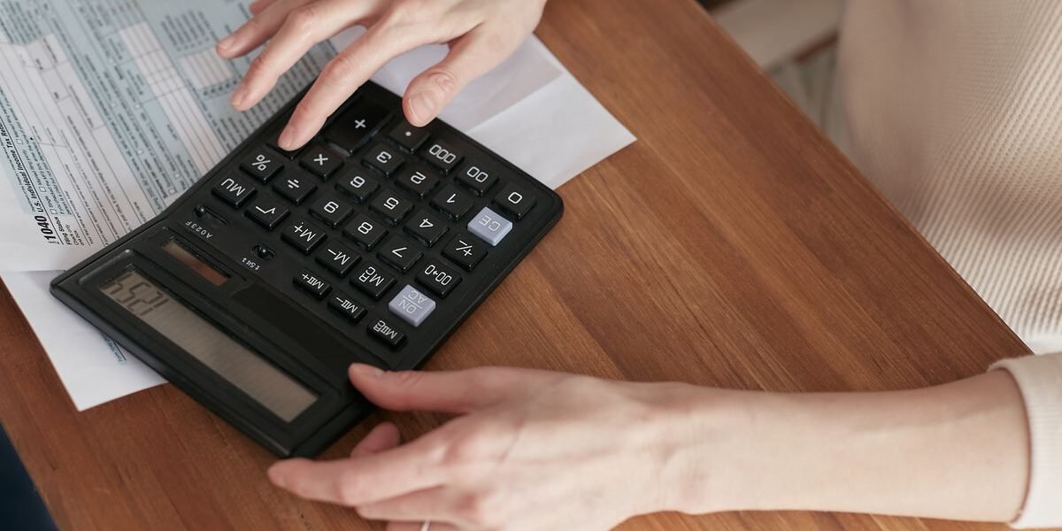 Ouders rekenen het gezinsbudget na met rekenmachine en papieren