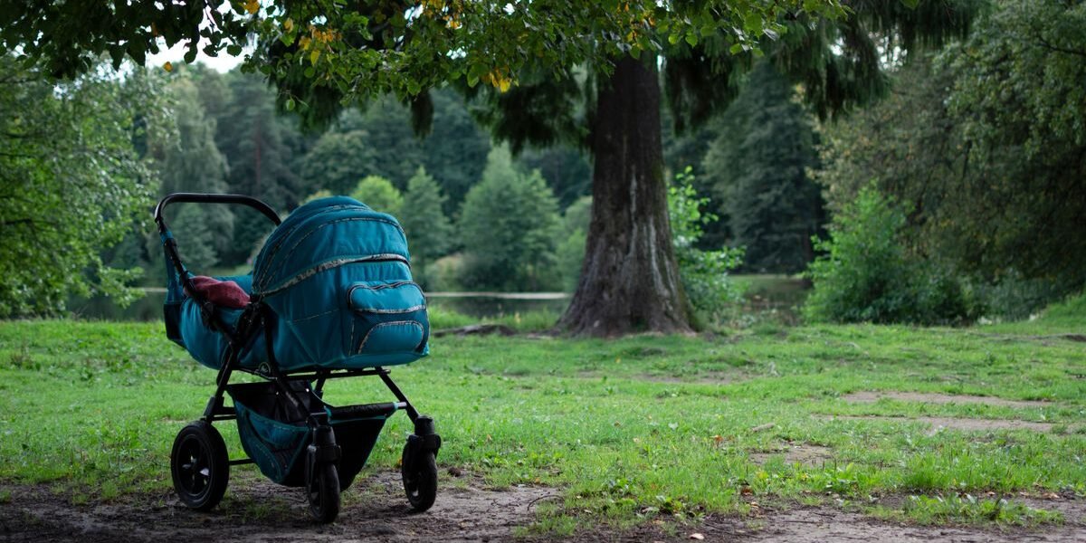 Ouders wandelen samen met hun kinderwagen, kinderwagen kopen waar op letten