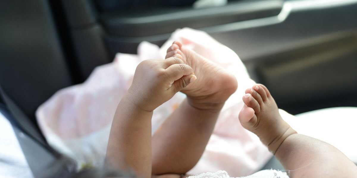 Babyvoetjes in een zonnige auto, wanneer autostoel baby vervangen