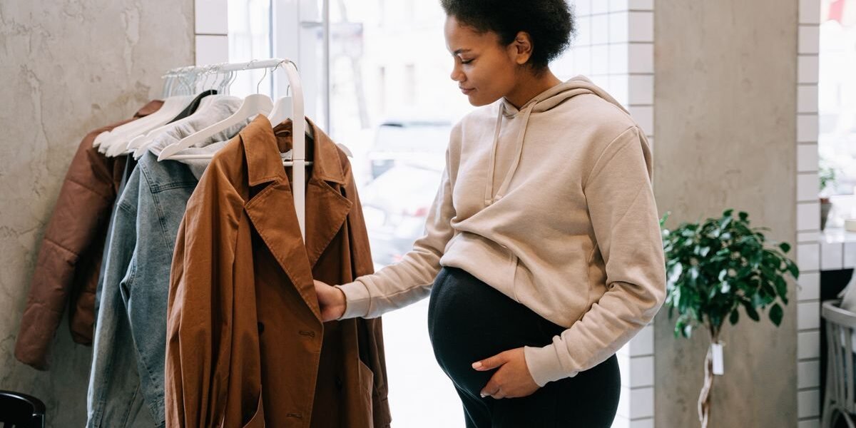 Zwangere vrouw kijkt rond in een winkel, wanneer kinderwagen kopen