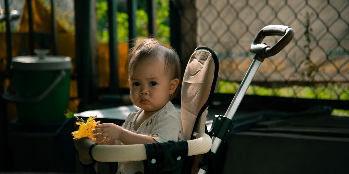 Baby zit rechtop in buggy met gele bloem, kinderwagen ombouwen naar buggy