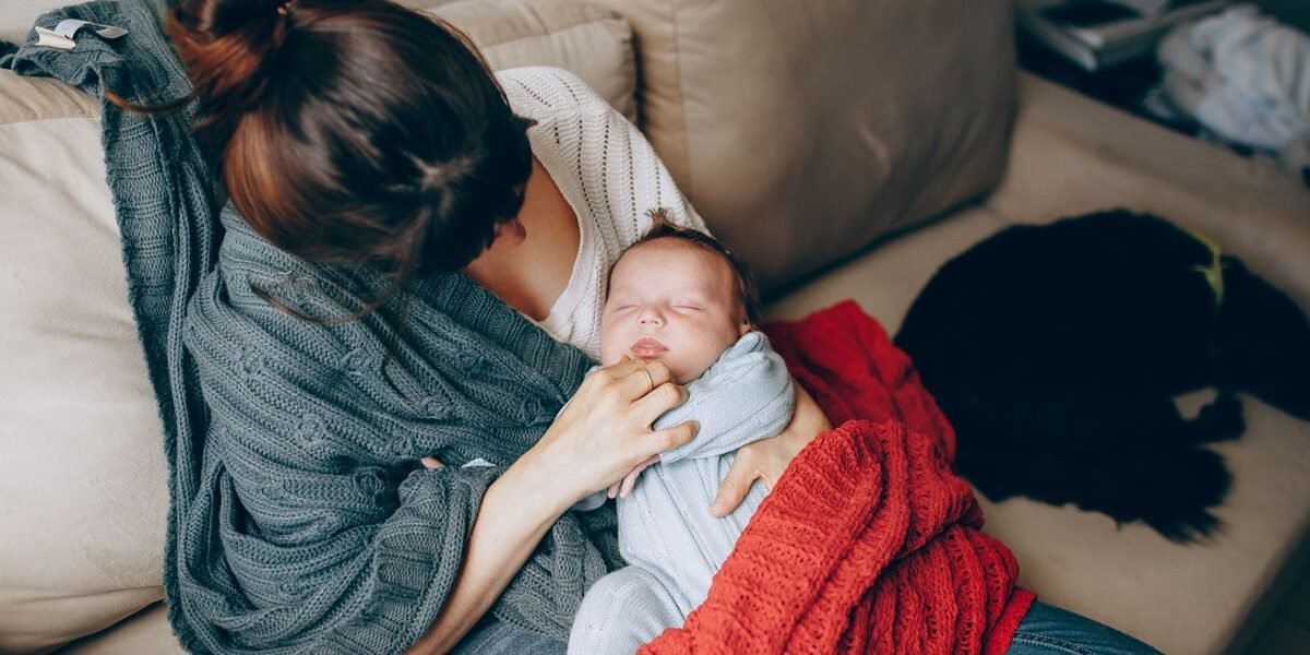 Mama met pasgeboren baby op de zetel, klaar voor kraambezoek