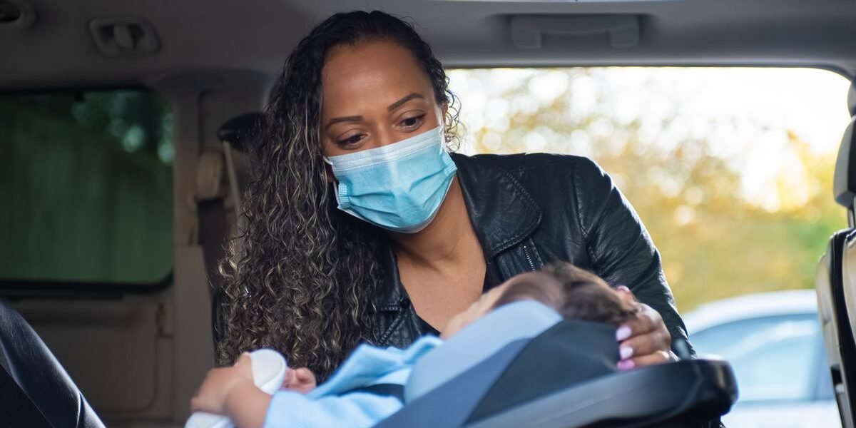 Moeder klikt haar baby vast in een autostoel, welke autostoel baby