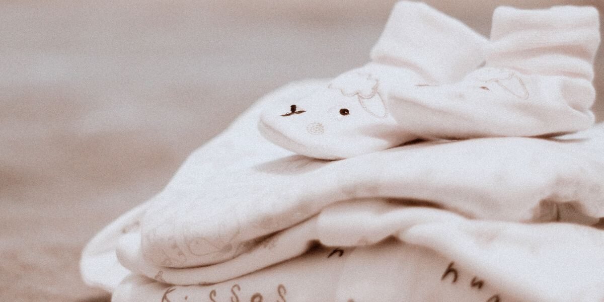 Witte babysokjes, een van de babykleertjes om mee te nemen naar het ziekenhuis