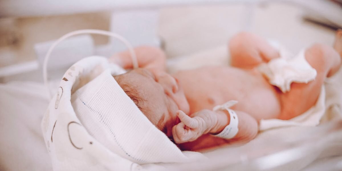 Ingebakerde pasgeboren baby in een ziekenhuisbedje na de bevalling