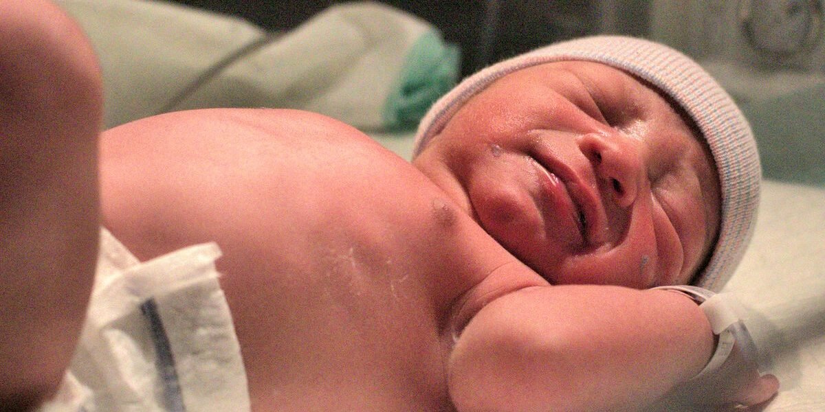 Pasgeboren baby in ziekenhuisdeken na een bevalling met keizersnede